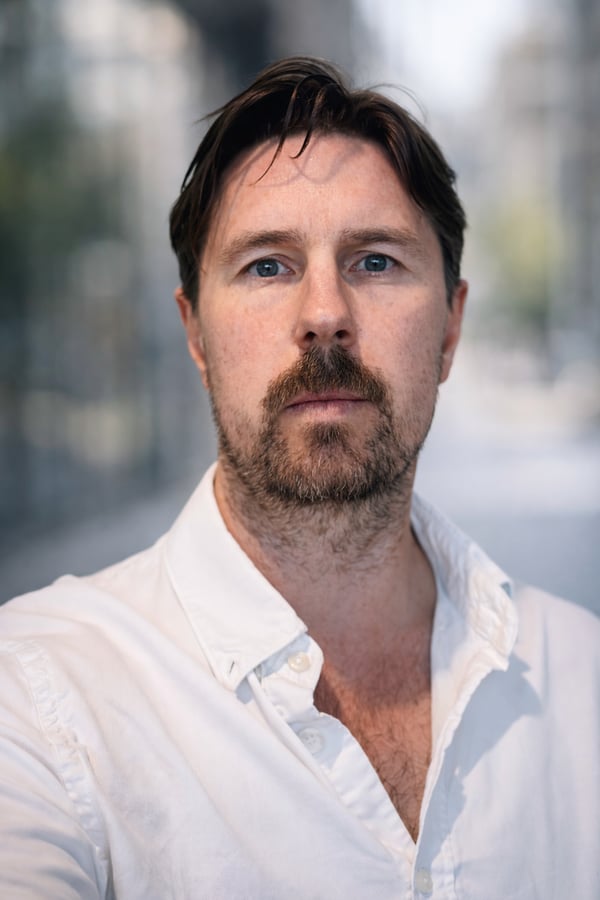 Porträtt av en man i vit skjorta utomhus