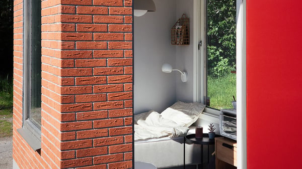 Minihus med sovplats, fönster och röd tegelfasad