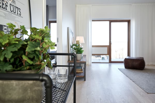 Lägenhet med ljus öppen planlösning, stora fönster och inredda detaljer