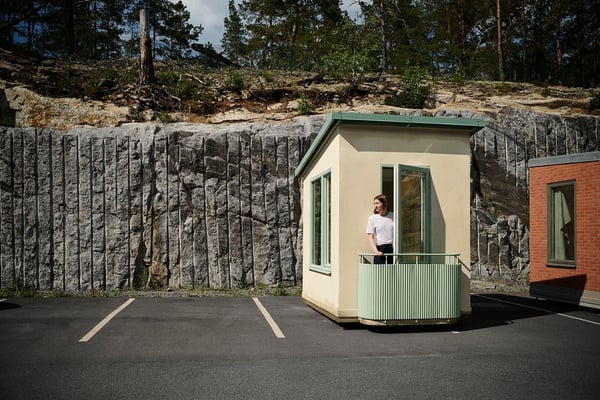 Minihus med balkong och kvinna utanför