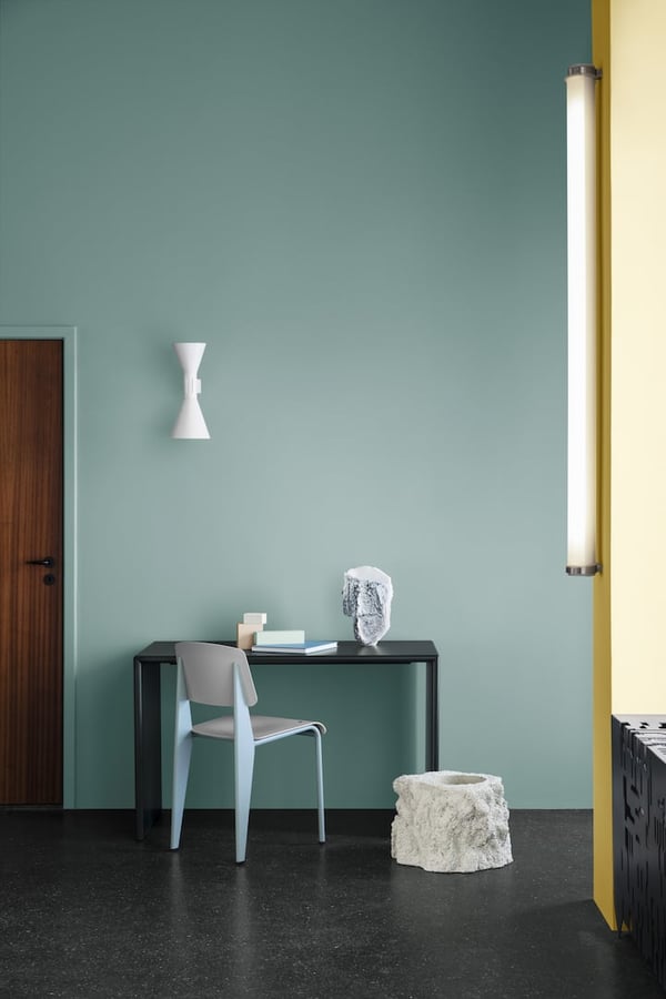 Lägenhet med mintgrön vägg, skrivbord och stol