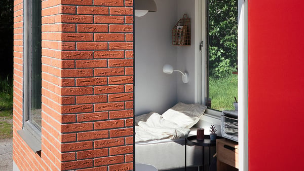 Minihus med sovplats, fönster och röd tegelfasad