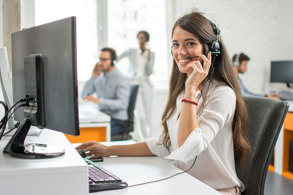Ung kvinna med headset i kunservice