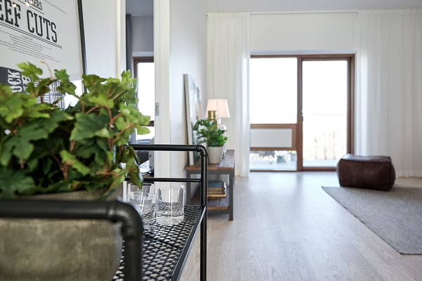 Lägenhet med ljus öppen planlösning, stora fönster och inredda detaljer