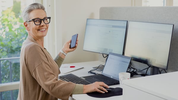 Kvinna som arbetar som ekonomisk förvaltare med telefon i handen