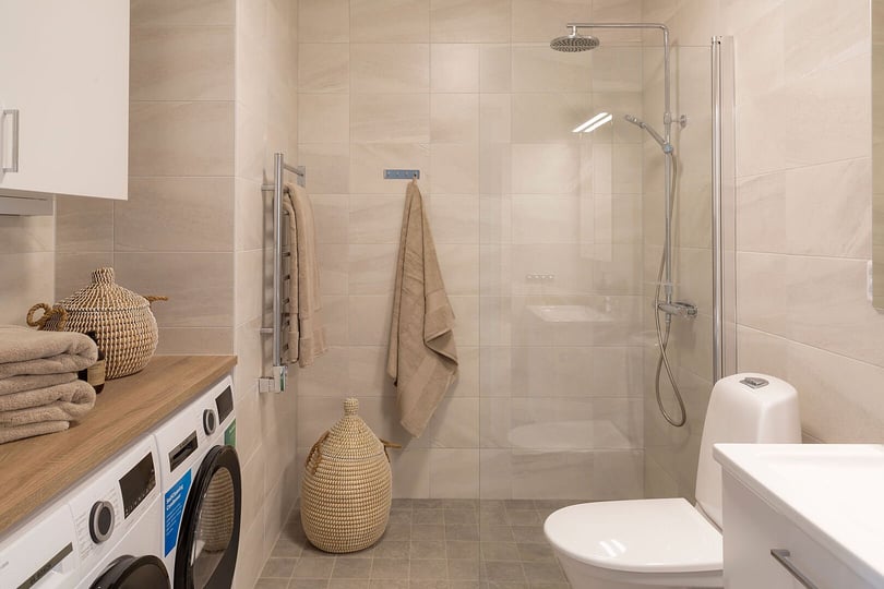 Badrum med duschörna och tvättmaskin och torktumlare i lägenhet på 3 rum och kök