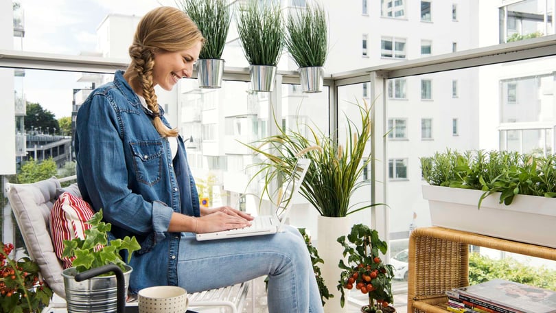 Kvinna på balkong med dator