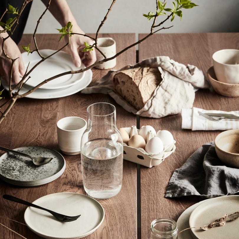 Matbord med bröd och ägg dukat i naturfärger