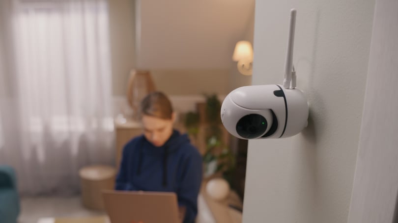 Kameraövervakning i ett rum innomhus men en tjej som surfar på en dator i bakgrunden.