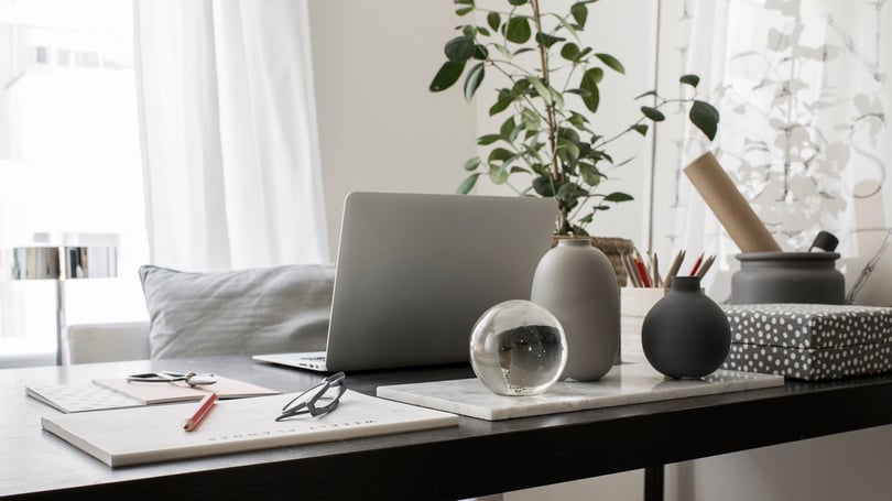 Skrivbord med dator och pennor på