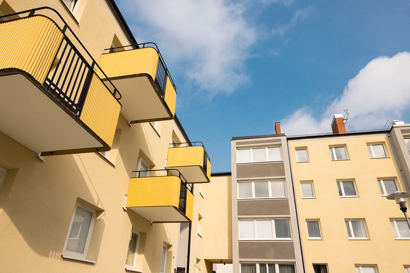 Renoverade balkonger på gul putsad fasad