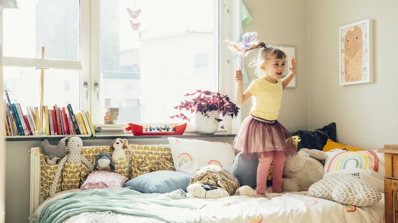 Barn hoppar på säng