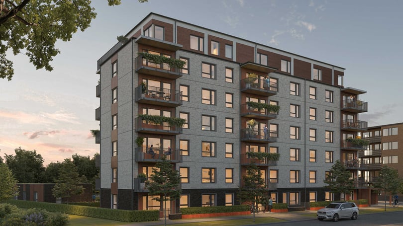 Flerfamiljshus med modern arkitektur, balkonger och stora fönster, omgiven av träd och en bil parkerad på gatan