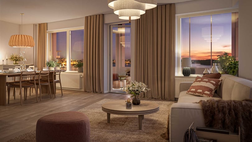 Modernt vardagsrum med soffa, soffbord och fotpall, ett matbord med stolar vid fönster, gardiner och dekorativ belysning, med utsikt över en solnedgång