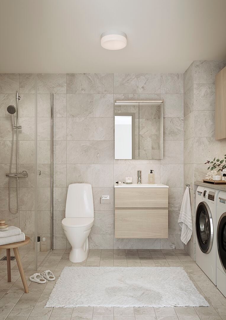 Modernt badrum med kaklade väggar, duschhörna, toalett, tvättmaskin, torktumlare, ljus matta och trädetaljer