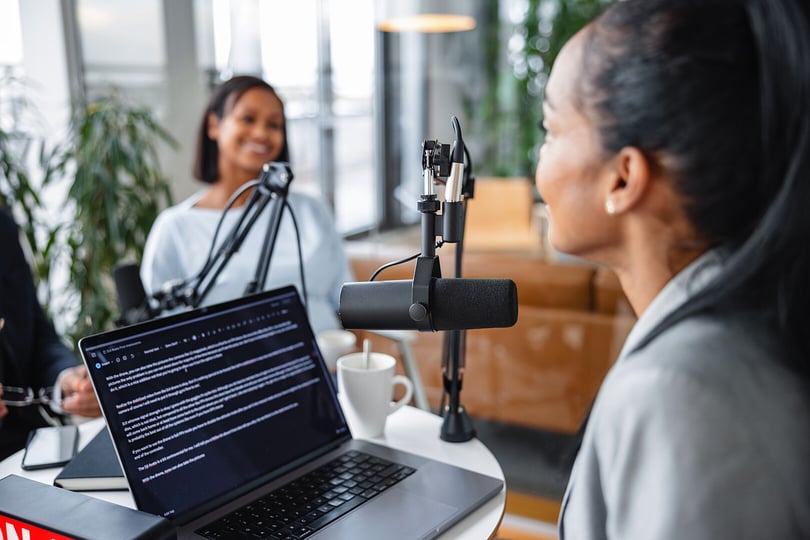 Två kvinnor i studio med dator och microfon