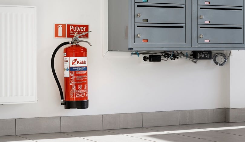 Brandsläckare uppsatt bredvid postfack i trappuppgång