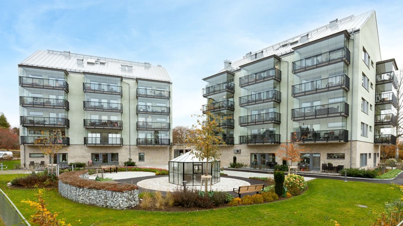 Nyproducerade flerbostadshus med balkonger och gemensam innergård