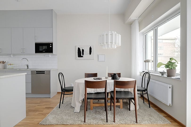 Inflyttningsklar lägenhet med kök och matplats i ljus, modern inredning