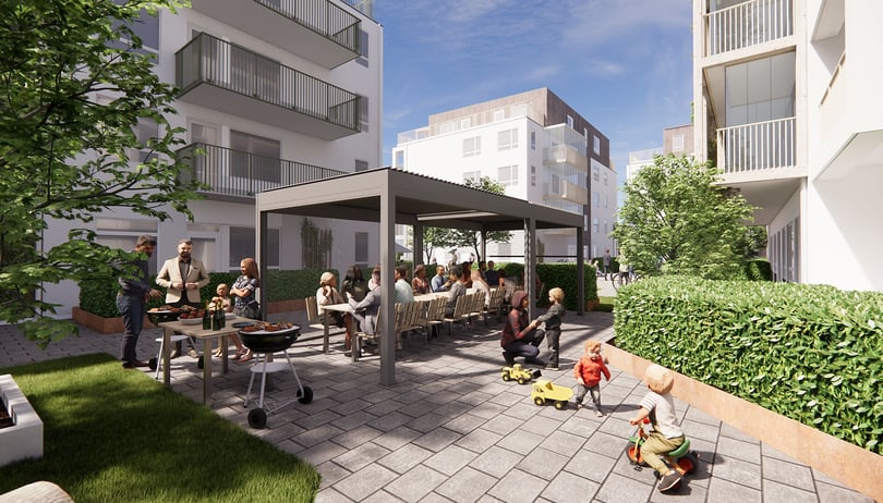 Människor samlas och umgås på en gemensam gård med sittplatser, grill och lekande barn