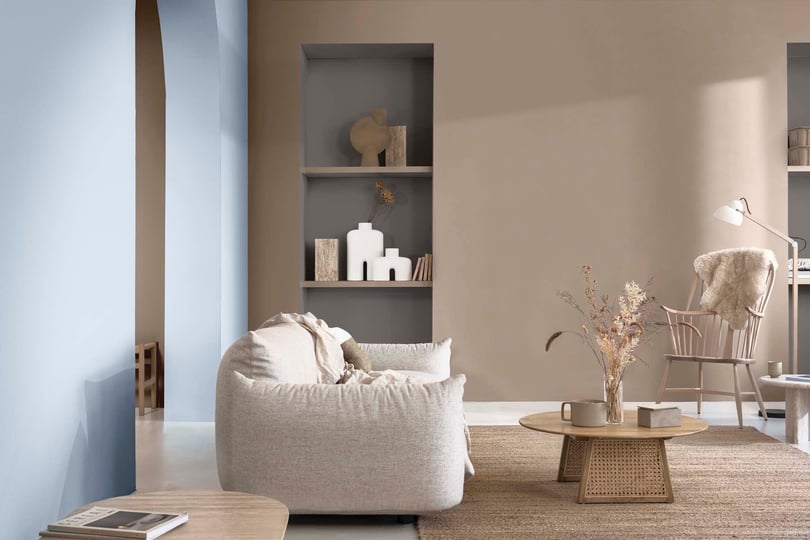 Lägenhet med ljus inredning, fåtölj, soffbord och dekorativa hyllor