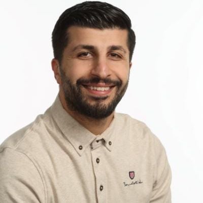 Porträtt av en man i beige skjorta mot vit bakgrund