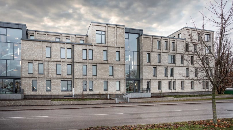 Flerbostadshus i modern tegelarkitektur med stora glaspartier och många fönster