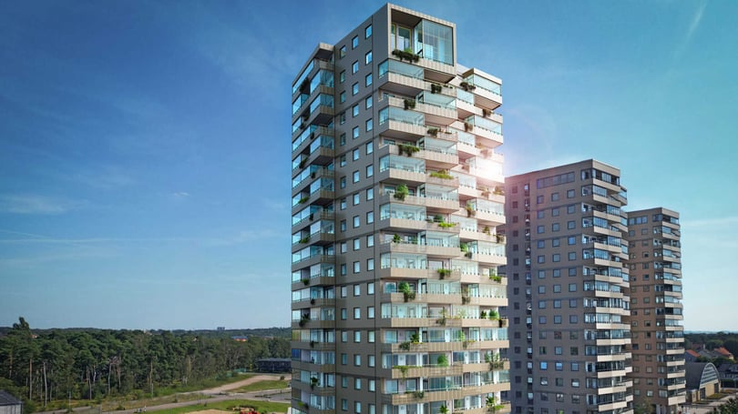 Flerbostadshus med balkonger och utsikt mot skog