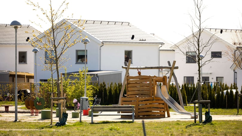 Lekplats i ett bostadsområde med radhus i bakgrunden