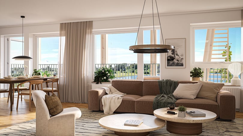 Ljust vardagsrum med brun soffa, fåtölj, matplats och stora fönster mot utsikt över vatten