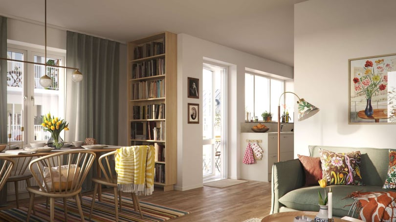 Ljust och modernt vardagsrum med matplats, bokhylla, grön soffa och färgglada kuddar, samt blommor och växter som dekoration