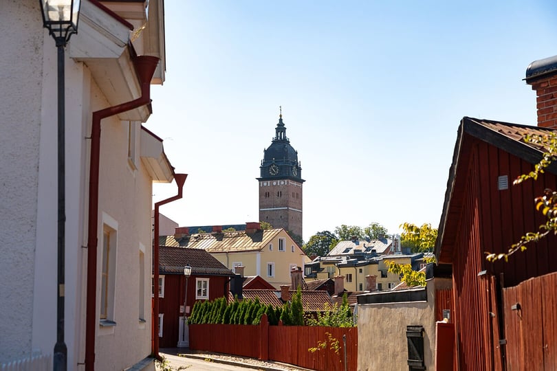 Vy över Strängnäs med färgade hus och kyrktorn i bakgrunden