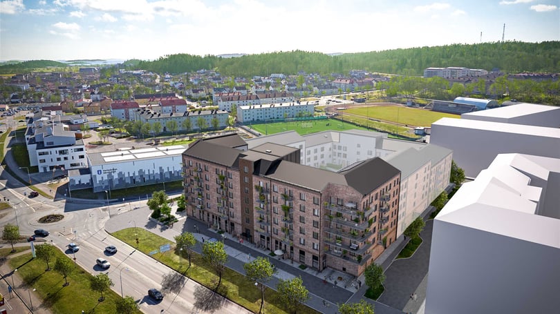 Flygvy över ett bostadsområde med flerbostadshus, gator och grönområden