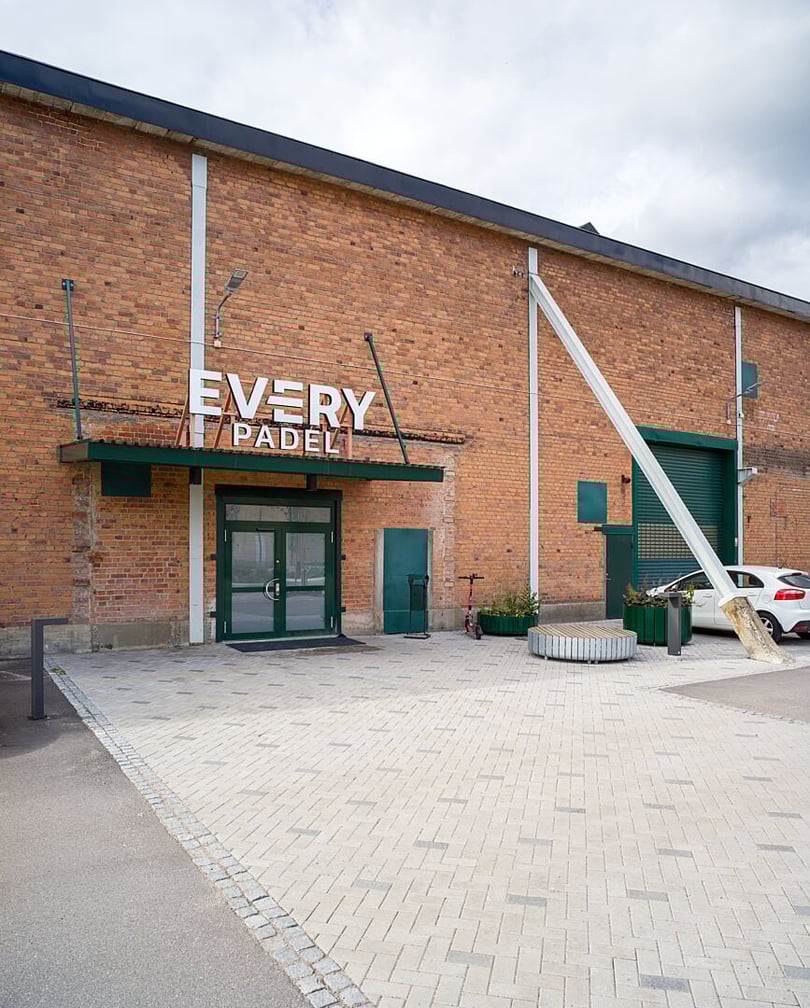 Fasad av tegelbyggnad med skylten Every Padel och entré med grön dörr