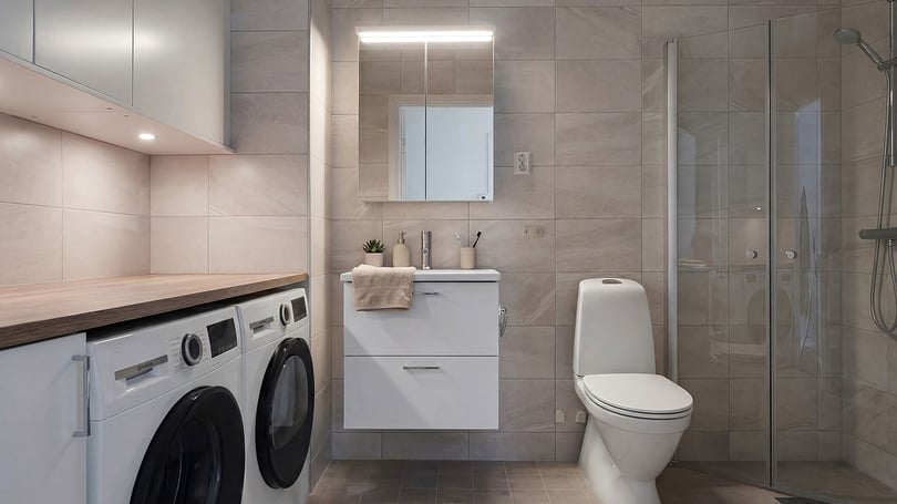 Inflyttningsklart badrum med tvättmaskin, torktumlare, dusch och toalett