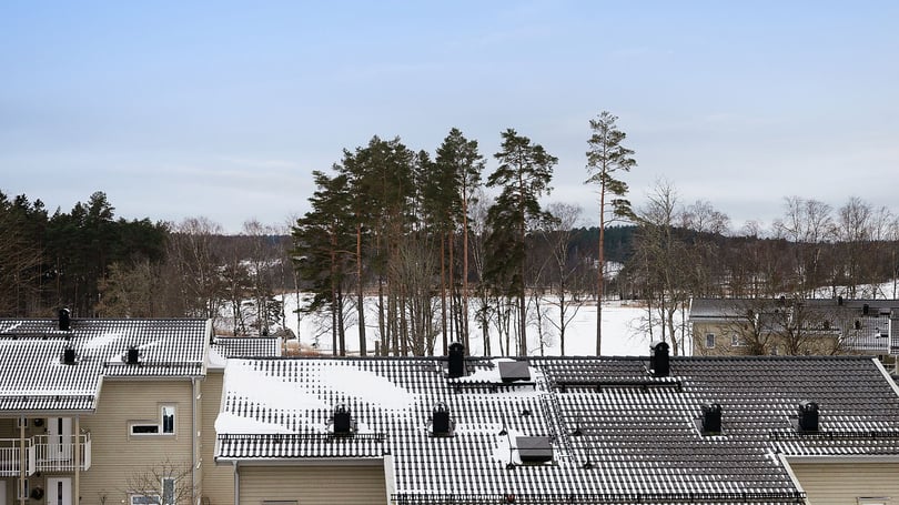 Vy över Korseberg Vik med snötäckta hustak och träd i bakgrunden