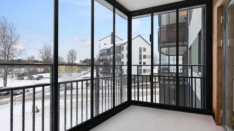 Inflyttningsklar lägenhet med inglasad balkong och utsikt mot snötäckt innergård