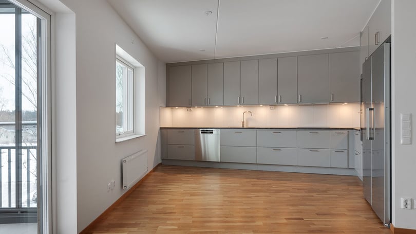Inflyttningsklar lägenhet med modernt kök, ljusa skåpsluckor och trägolv