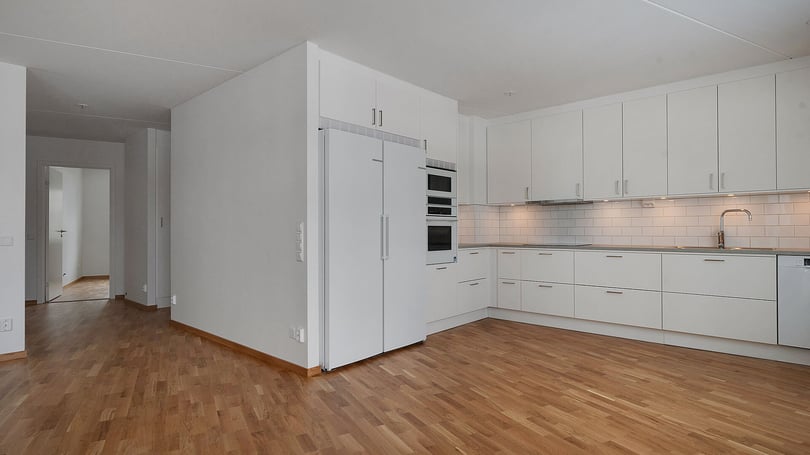 Inflyttningsklar lägenhet med vitt kök och trägolv