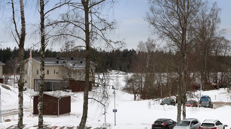 Vintermiljö med hus, träd och parkerade bilar