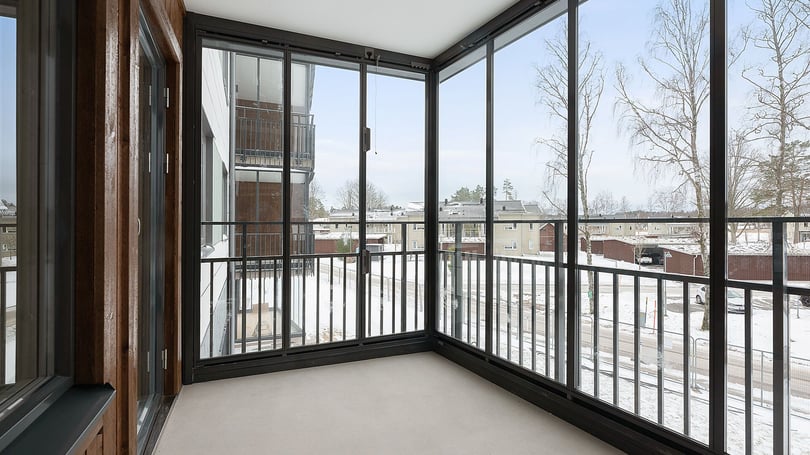 Inflyttningsklar inglasad balkong med utsikt över snöigt bostadsområde