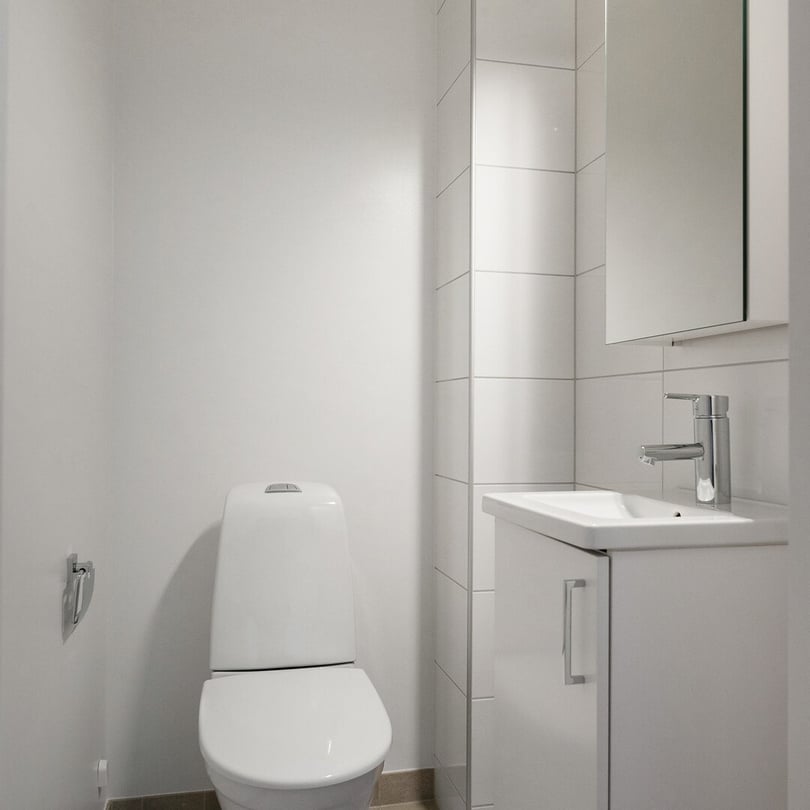 Inflyttningsklart wc med vitt handfat, spegelskåp, toalett och spegelskåp