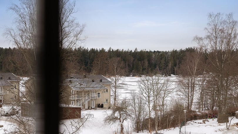 Inflyttningsklar lägenhet med utsikt över snötäckt område och träd