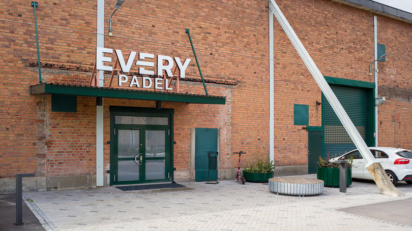 Fasad med entré till Every Padel, tegelvägg, grön dörr och parkerad bil