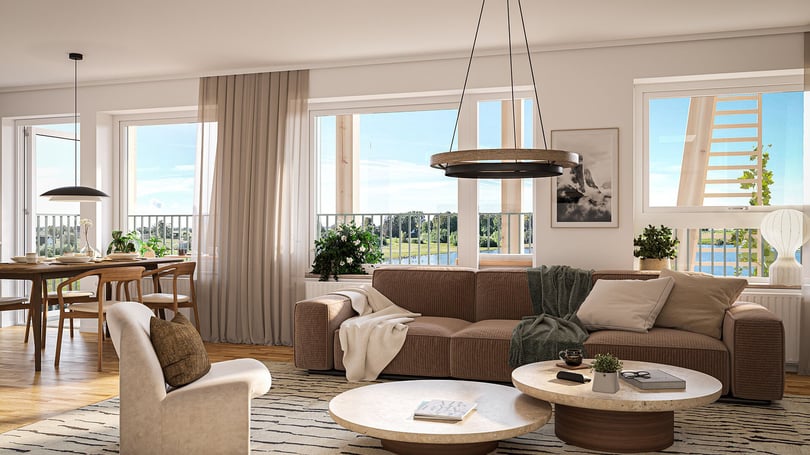Ljust vardagsrum med brun soffa, fåtölj, matplats och stora fönster mot utsikt över vatten