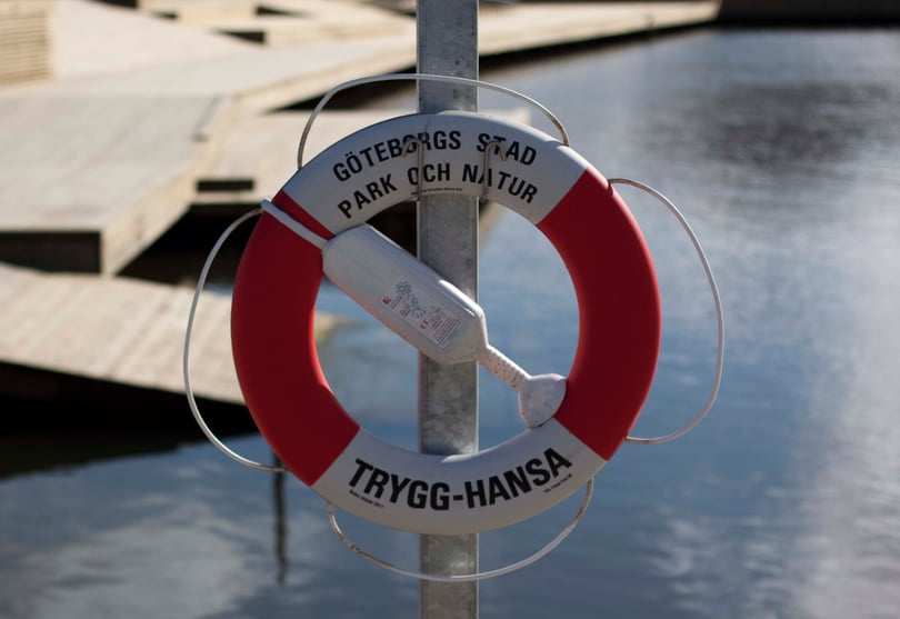 Livboj med texten Göteborgs stad Park och natur samt Trygg-Hansa vid en brygga