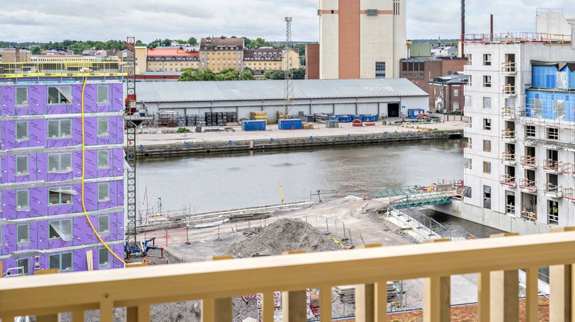 Bostadsbygge vid vattnet med flera flerbostadshus i olika byggskeden