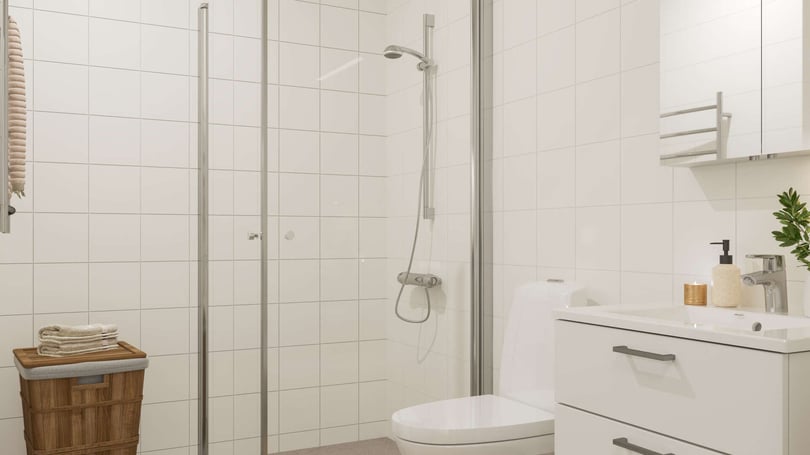 Badrum med dusch, toalett och handfat i ljusa material