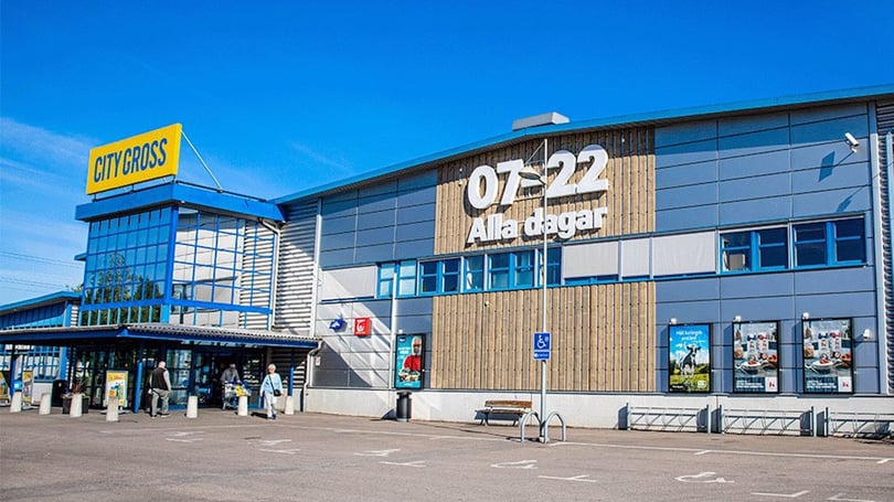 Exteriör av City Gross butik med blå fasad och skyltar, människor utanför entrén