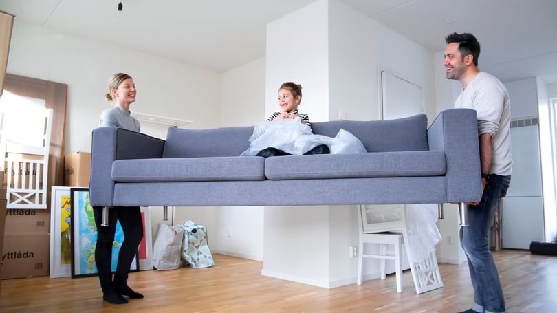 Lägenhet med tre personer som bär en soffa